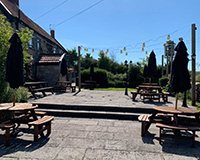 Outside area of The Wishing Well pub with socially distance tables